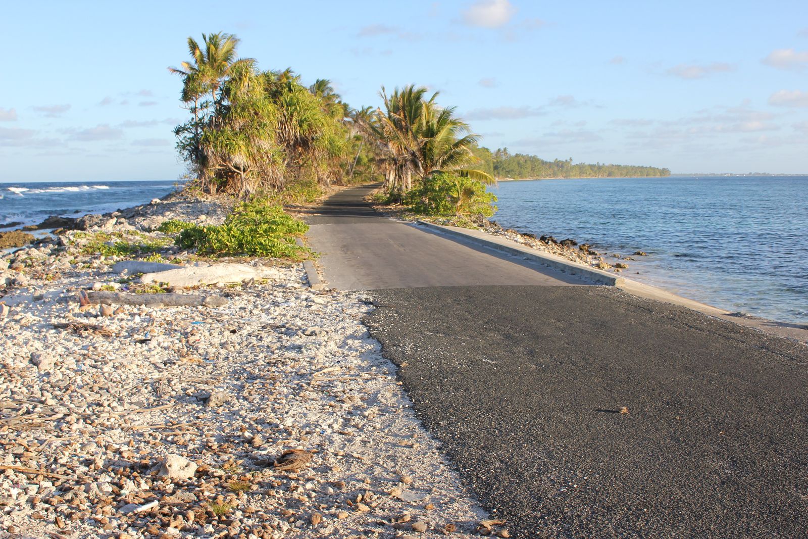 A road runs along a narrow, low-lying strip of atoll land between lagoon and ocean in Tuvalu, photographed in October 2011.