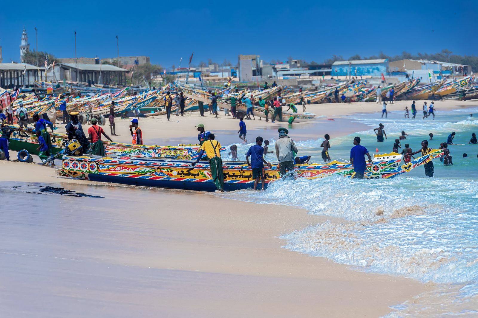 Fishers arrive on the beach at Kayar, Senegal, with pirogues loaded with fish, in July 2024.